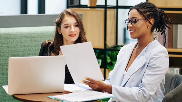 Two women looking at documents in an office