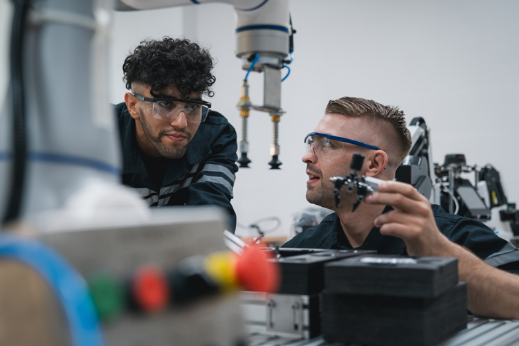 Student engineer assembling robotic arm on lab
