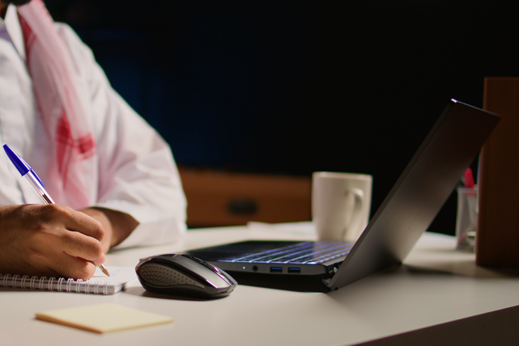 Online teaching professor writing with a pen