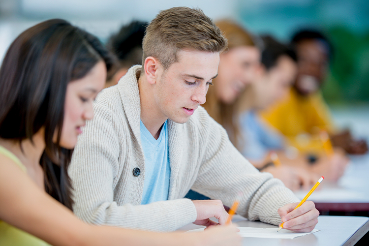 Group of students taking an exam in class